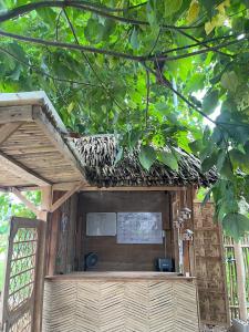 an outside view of a building under a tree at Lawi Haven Homestay in Burgos