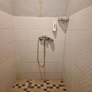 a shower in a bathroom with a phone on the wall at Tara hostel in Nusa Penida +28 photos