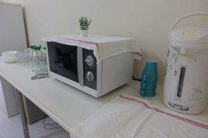 a table with a microwave on top of a counter at V Home Apartment in Ban Chek