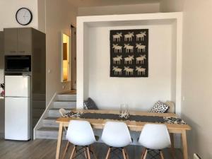 a dining room with a table and four white chairs at Alpina Apartment 1 in Falls Creek +12 photos