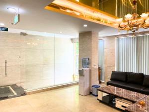 a living room with a couch and a glass wall at Khách sạn Hồ Giám in Hanoi