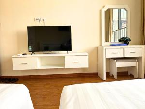 a white dresser with a tv in a bedroom at Khách sạn Hồ Giám in Hanoi