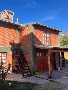 a red brick building with a staircase on the side of it at Las Dolinas 3 in Malargüe