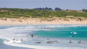 WangoomPine Hill Tiny House by Tiny Away的一群人在海滩的水中