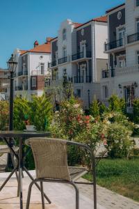 ein Tisch und Stuhl auf einer Terrasse mit Gebäuden in der Unterkunft Lamer Sea Breeze Resort in Baku