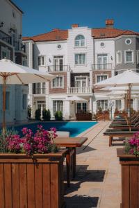 ein Pool mit Tischen und Sonnenschirmen vor Gebäuden in der Unterkunft Lamer Sea Breeze Resort in Baku