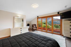 a bedroom with a bed and a dresser and a mirror at Macpherson Street, Wanaka in Wanaka +29 photos