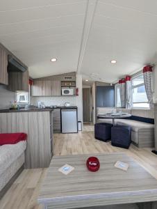 a kitchen and a living room with a couch and a table at Pet-Free Swift Burgundy Family Holiday Home at Littlesea Holiday Park, Weymouth in Wyke Regis