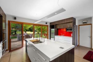 a large kitchen with a white counter top and cabinets at Macpherson Street, Wanaka in Wanaka