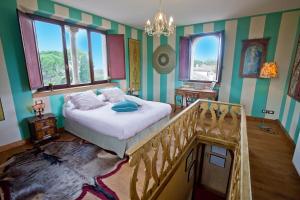 a bedroom with a bed and a staircase and windows at Villa Verecondi Scortecci in Colle Umberto +57 photos