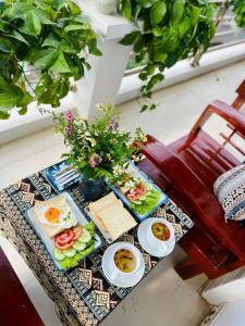 ハザンにあるĐá Gió Hà Giang Homestayの椅子の上に卵とパンが置かれた朝食用のテーブル