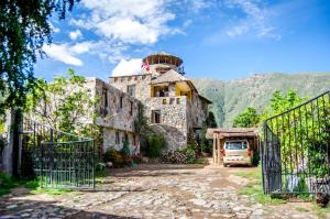 ein altes Steinhaus mit einem Tor davor in der Unterkunft Hotel Kuntur Wassi in Cabanaconde