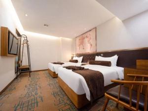 a hotel room with two beds and a chair at James Joyce Coffetel·Shenyang North Railway Station Shifu Square in Shenyang