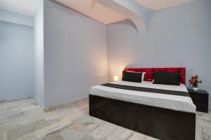 a bedroom with a large bed with a red headboard at Hotel O Blue moon in New Delhi