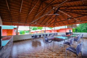 a dining room with tables and chairs in a building at River Raga Nature Resort in Kārkāl