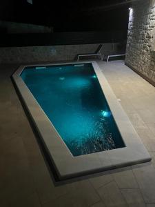 a swimming pool with blue water in a building at Hidden Oasis - pool, playground - 3 min from the beach in Vir