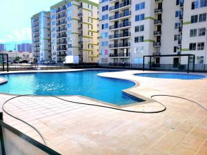 a swimming pool in an apartment complex with tall buildings at Bonito Aparatemnto con Piscina in Santa Marta