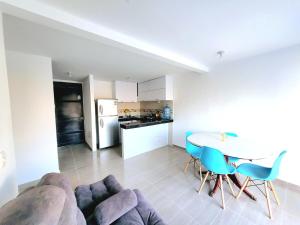 a kitchen and a living room with a table and chairs at Bonito Aparatemnto con Piscina in Santa Marta