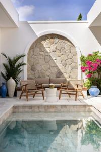 una piscina en una casa con 2 sillas y un sofá en Villa Lisbon Premium by Tofino Villas, en Uluwatu