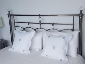 a bed with two white pillows and a metal headboard at Halfway House Hotel in Larne