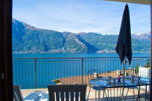 balcone con tavolo, sedie e vista sulle montagne. di Residence Dorio a Dorio