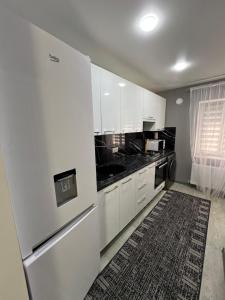 eine Küche mit weißen Schränken und schwarzen Arbeitsplatten in der Unterkunft 1-Edinet apartament Квартира Единец in Edineţ