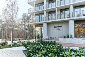 a building with a bunch of plants in front of it at Golden Hour Apartments- Loft H 214 in Świnoujście