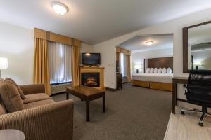 a hotel room with a living room with a bed and a fireplace at Ramada Golden in Golden