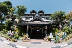 a building with potted plants in front of it at Baan Orawee Boutique Hotel in Mae Rim