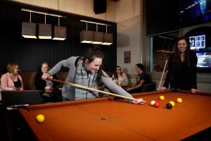 a woman playing snooker in a pool table at Stay at the historic Star Hotel in Sale