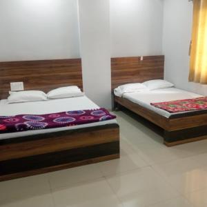 due letti singoli in una stanza con tre tete e tre tete e tre e tre e tre. di Hotel Sai panchwati grand shirdi a Shirdi Altre 4 foto