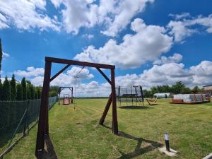 an empty playground with a swing set in a field at Lawendowy Domek Boutique Resort, Zator, Przeciszów in Zator