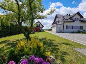 a house with a tree and flowers in the yard at Lawendowy Domek Boutique Resort, Zator, Przeciszów in Zator