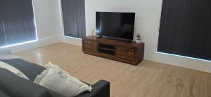 Una sala de estar con un televisor de pantalla plana y un sofá. en Bloomfield, en Westfield