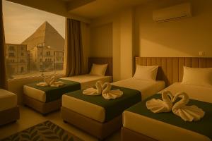 una camera d'albergo con tre letti con fiocchi sopra di Pyracave pyramids view a Il Cairo
