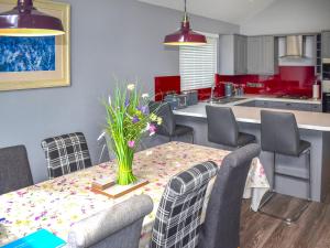 Una cocina con una mesa con un jarrón de flores encima. en Oak Park Two - Uk50063, en Tiverton