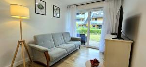 a living room with a couch and a television at TriApart Apartamenty Amber Beach Jantar in Jantar