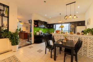 a kitchen and dining room with a table and chairs at HA Gateway Inn Hoian Priavate Pool Villa in Hoi An