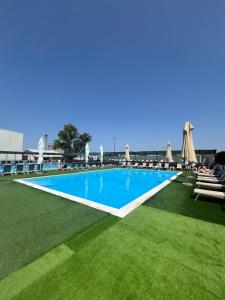 una piscina con sedie a sdraio e ombrelloni di Sole Mio Wellness & SPA a Novi Sad