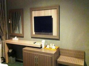 een badkamer met een tv op de hoek van een kamer bij Royal Denai View Syariah in Bukittinggi +76 foto's