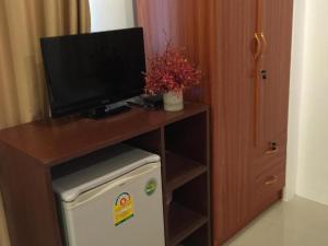 a room with a desk with a television and a refrigerator at The Royhanna Beach House in Tab Kaek Beach
