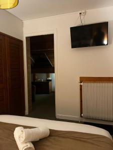 a bedroom with a bed and a television on the wall at Hôtel Au Feu De Bois in Autrans +86 photos