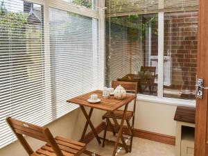 a table and two chairs in front of a window at Selkie Cottage in Corton