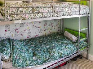 a bunk bed in a room with a bedsheet on at Selkie Cottage in Corton