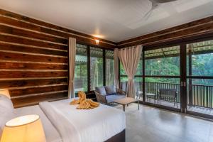 una camera con letto, sedia e finestre di Rompin Rainforest Lodge a Kuala Rompin