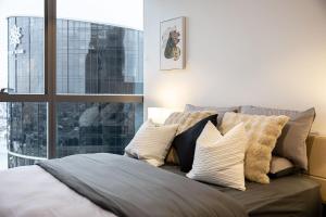 Un dormitorio con una cama con almohadas y una ventana. en Brisbane River view 2BR apt at casino QW, en Brisbane