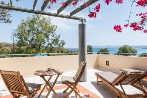 d'une terrasse avec des chaises et une table et une vue sur l'eau. dans l'établissement Forum Suites, à Kato Daratso