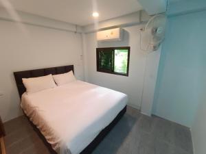 Cama blanca en habitación pequeña con ventana en Cosy Chill, en Ko Pha Ngan 11 fotos más
