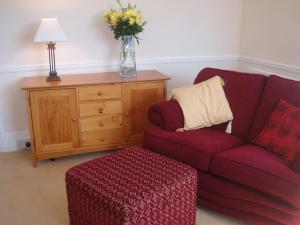 a living room with a couch and a vase of flowers at Copper Beech Rooms in Newquay