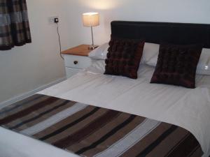 a bed with two pillows on it in a room at Copper Beech Rooms in Newquay